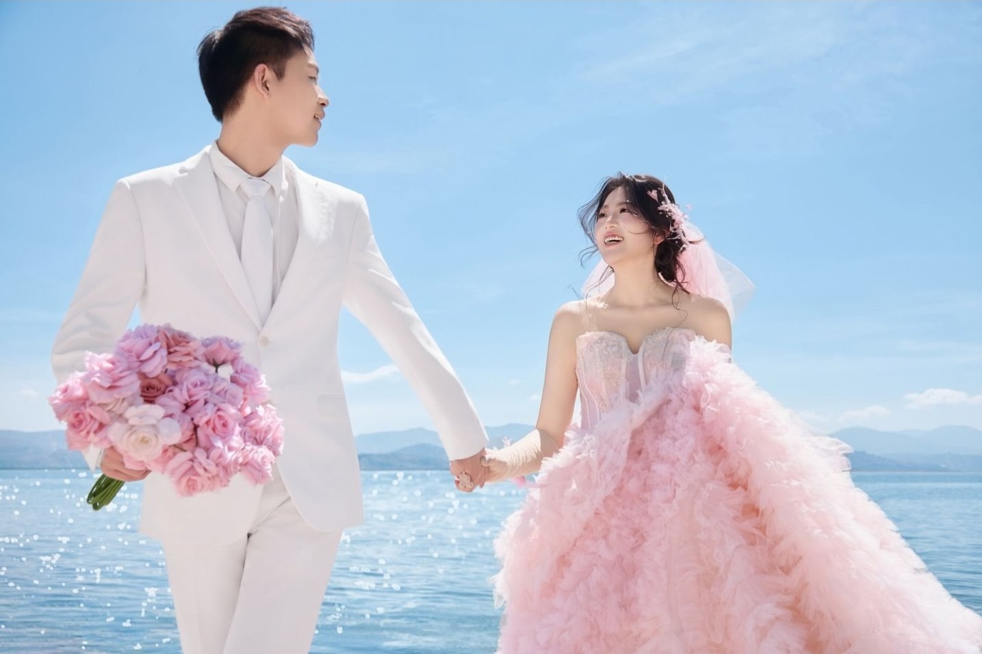新人在海边牵手的婚纱照